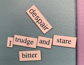 A magnetic poem against a blue and purple background that says “Despair / I trudge and stare / Bitter.”